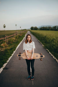 Full length of woman holding skateboard