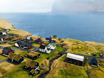 High angle view of buildings by sea against sky