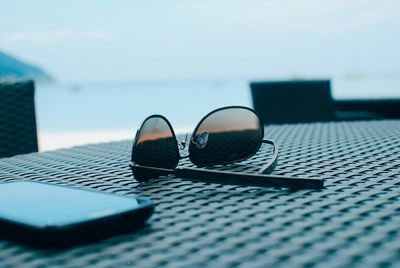 Close-up of sunglasses and smart phone on table