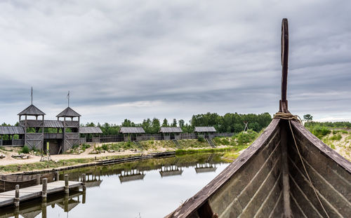 Panoramic view of factory by lake against sky