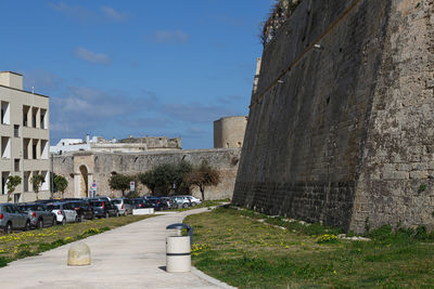 Footpath amidst buildings against sky