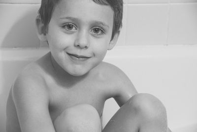 Portrait of smiling boy sitting in bathtub