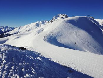 Scenic view of snowcapped mountains against clear blue sky