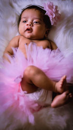 Portrait of young baby lying on bed at home