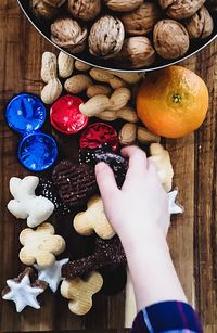 High angle view of hand holding fruits on table