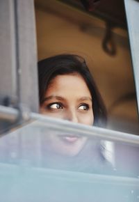 Beautiful woman looking through window in vehicle