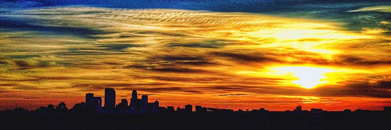 Silhouette of cityscape against dramatic sky