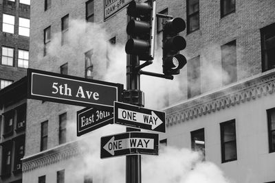 Low angle view of directional signs on road signal against building