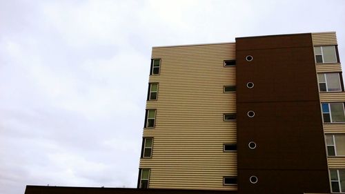 Low angle view of building against cloudy sky