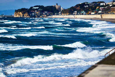 Scenic view of sea with rushing waves against sky