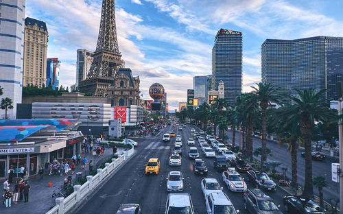 Traffic on city street amidst buildings against sky