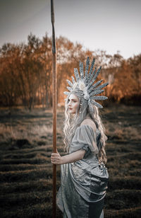 Young woman standing on field in forest