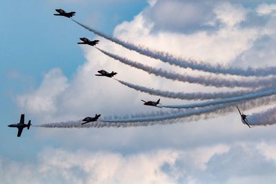 Low angle view of fighter planes flying against sky