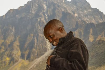 A hiker against a blurred background of mount baker, rwenzori mountains, uganda