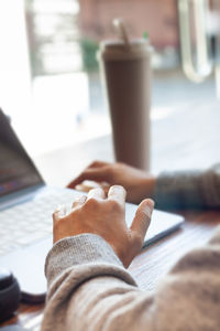 Midsection of woman using laptop on table