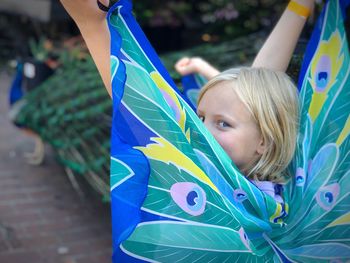 Portrait of girl wearing butterfly wings outdoors