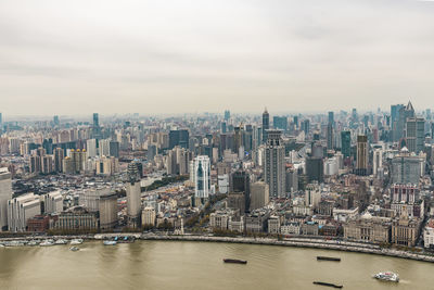 Aerial view of buildings in city against sky