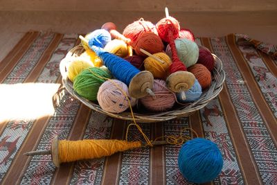 Colorful wool in basket on table