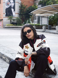 Portrait of young woman sitting on street