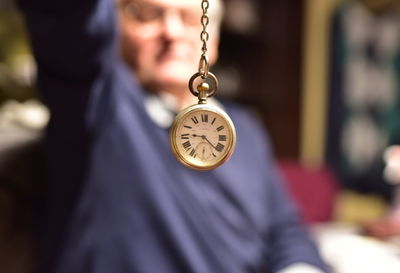 Midsection of man holding pocket watch