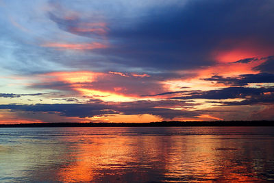 Scenic view of sea against dramatic sky during sunset