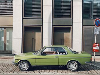 Vintage car on street against building in city