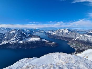 Scenic view of snowcapped mountains against blue sky