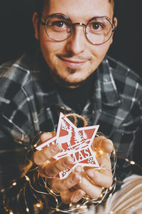 Portrait of young man holding eyeglasses