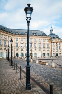 Low angle view of street light against place de la bourse in city