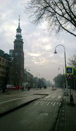 View of city street against cloudy sky