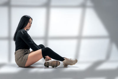 Portrait of young woman sitting on floor