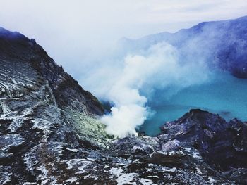 Smoke emitting from volcanic mountain against sky