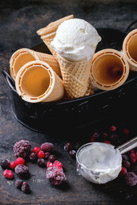 High angle view of ice cream cones by frozen berries on table