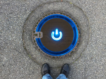 Low section of man standing manhole with illuminated star button
