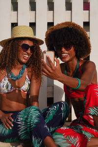 Two young black women taking selfie at the beach