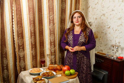 Portrait of young woman holding fruits at home