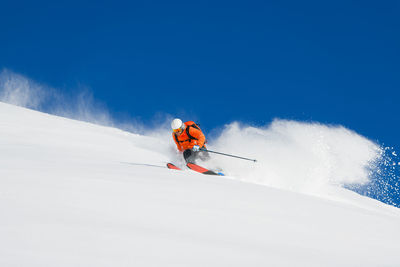 Low angle view of man skiing on snow covered landscape