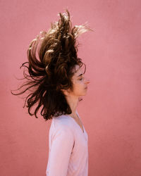 Portrait of woman against pink background