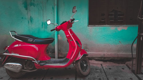 Side view of motor scooter against wall
