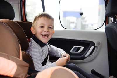 Portrait of smiling boy sitting in car