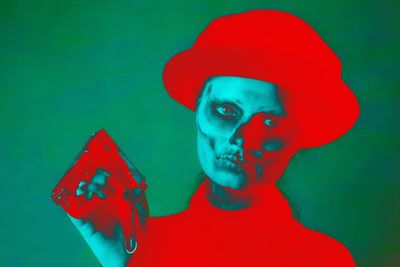 Close-up portrait of human hand against colored background