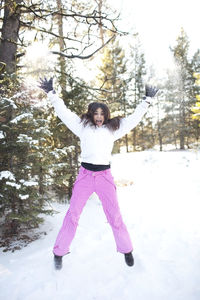 Full length of smiling girl standing in snow