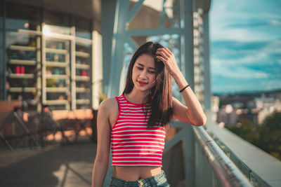 Beautiful young woman standing against built structure