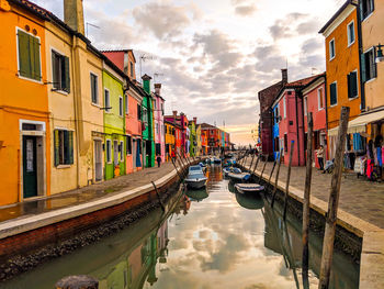 Canal amidst buildings against sky