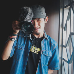 Portrait of young man holding camera