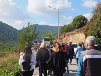 Rear view of people walking on road