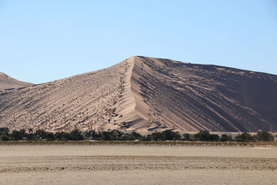 Scenic view of sand against clear sky