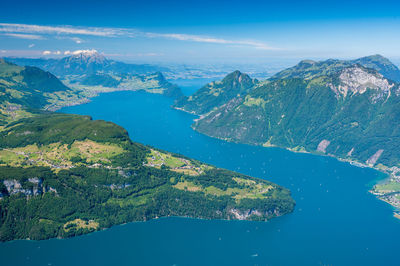 Aerial view of lake and mountains against blue sky