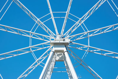 Low angle view of ferris wheel against clear blue sky