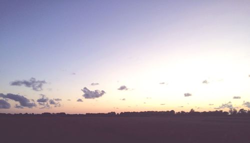 Scenic view of silhouette field against clear sky during sunset